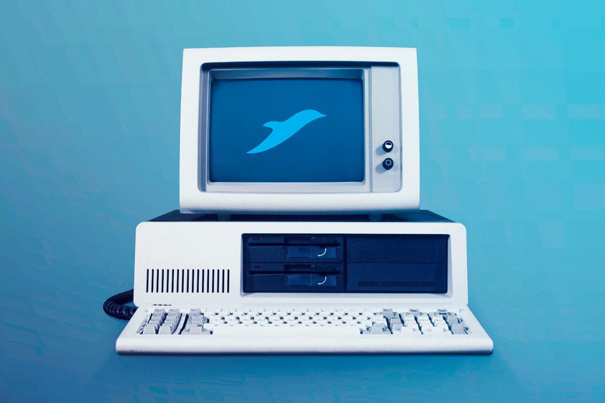 Das Bild zeigt einen antiquierten Computer vor blauem Hintergrund. Auf dem Röhrenmonitor ist der sellify Delfin zu sehen